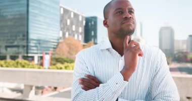 Düşünceli bir işadamı bir sonraki hamlesini düşünerek şehirde duruyor. Kentsel ortam hırsı ve kariyer hedeflerini yansıtıyor..