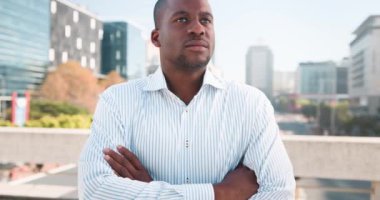Genç, siyah bir işadamı kollarını kavuşturup şehrin çatısında duruyor. Uzağa bakıyor ve şirketinin geleceğini düşünüyor. Kendinden emin ve kararlı görünüyor.. 