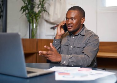 Modern bir çalışma alanında kendine güveni olan bir adam iş görüşmelerini dizüstü bilgisayarla yapar. İmaj, çağdaş bir iş ortamında profesyonellik, odak ve üretkenlik taşır..