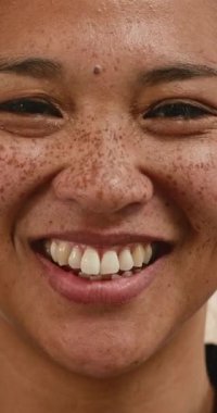 Çilleri parlak gülümseyen genç bir kadının yakın çekimi. Gerçek mutluluğu, pozitif ve neşe dolu bir şekilde yansıyor. Güzellik, kendine güven ve özgüvenle ilgili projeler için mükemmel..