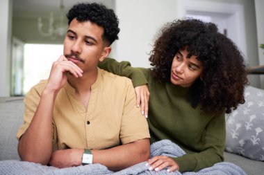 Bir çift evdeki koltuklarında oturur, derin düşüncelere dalarlar. Kadın destekleyici görünüyor. Uzağa dikkatlice bakan ortağına yakın duruyor. - Ne? Bir bağ ve duygu anı.