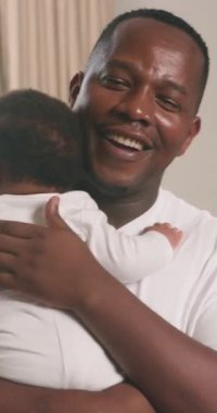 Sevgi dolu bir Kara Baba 'nın tapılası bebeğini kucaklamasının yürek ısıtan bir videosu. Baba kameraya gülümser, neşe ve şefkat saçar. Hassas an ailenin özünü yakalar ve bir ebeveyn ile çocuk arasındaki özel bağı..