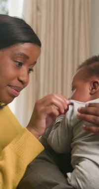 Sevgi dolu bir anne, sevimli bebeğiyle nazikçe etkileşime geçer ve iç açıcı bir aile bağı sahnesi yaratır. Şefkatli an, ailelerinin sevgi ve ilgisinin özünü evlerinin rahatlığında yakalar..