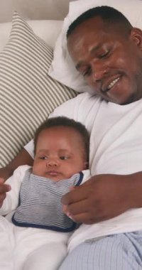 Sevgi dolu bir baba, küçük oğluyla yatakta yatıyor. Birbirlerine bakıp gülümsüyorlar. Ellerini hareket ettirirler ve parmaklarına bakarlar. Aile, rahatlatıcı bir sabahta mutlu ve neşeli..