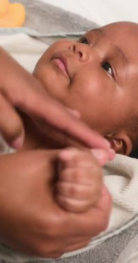 Bir anne banyo zamanından sonra sevimli bebeğine nazikçe masaj yapar. Bebek, annesinin ona sevgisiyle baktığı gibi mutlu ve memnun. Bu iç açıcı sahne ebeveyn ve çocuk arasındaki özel bağı yakalar..