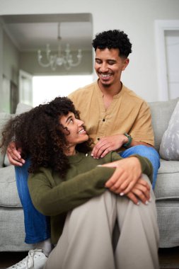 Keyifli bir çift, sıcak oturma odalarında keyifli bir anı paylaşıyor, neşe ve bağlantı sergiliyorlar. Sıcak atmosfer, günlük çevrelerinde samimi ve sevgi dolu bir ilişkiyi yansıtır..