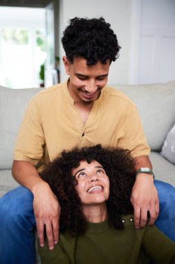 Neşeli genç bir çift, çağdaş evlerinde birlikte sevgi dolu ve samimi bir anın tadını çıkarıyor. Doğal ışık onların ifadelerini geliştirir, sıcaklıklarını, bağlantılarını ve mutluluklarını gösterir..