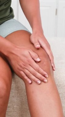 Dize nazikçe masaj yapan siyahi birinin elleri. Ağrı, yaralanma ya da kas zorlanması belirtisi. Bu kişisel bakım, iyileşme ve fizyoterapi ya da spor tıbbına ihtiyaç olduğunu gösterir..