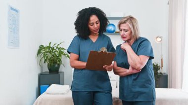 İki farklı kadın fizyoterapist, biri deneyimli diğeri de akıl hocası modern bir klinikte birlikte çalışıyorlar. Spor bilimi alanında küçük bir işletme içinde profesyonel akıl hocalığı ve uzmanlık paylaşımına örnek olarak hasta kayıtlarını bir panoda tartışıyorlar..