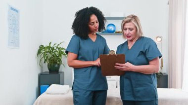 İki kadın fizyoterapist, deneyimli bir akıl hocası ve genç bir meslektaşı, kendi küçük işletme sağlık kliniklerinde işbirliği yapıyorlar. Hasta notlarını gözden geçirirler, spor bilimi uygulamalarını ve müşteri bakımını tartışırlar..