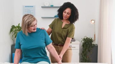 Kendini adamış siyahi bir kadın fizyoterapist tecrübeli bir hastaya nazikçe kol egzersizleri ve rehabilitasyonlarında yardımcı oluyor. Bu oturum, destekleyici bir klinik ortamında iyileşmeyi, hareket kabiliyetini ve genel fiziksel sağlığını teşvik etmektedir..