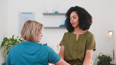 Deneyimli siyahi kadın fizyoterapist kıdemli bir hastaya özel bakım sağlıyor. Hastaya etkili fizyoterapi için özel kol hareketlerinde rehberlik ediyor. Klinik ortamında dayanıklılık, hareketlilik ve iyileşme sağlıyor..