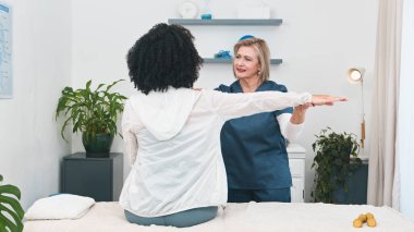 Aynı zamanda iş sahibi olan kıdemli bir fizyoterapist genç siyah bir müşteriye spor masajı ve fizik tedavi sağlıyor. Odak noktası sırt ve omuz sağlığı. Bu video, küçük bir uygulama ortamında kişiselleştirilmiş bakımı vurgular