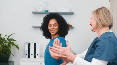 Yetenekli bir kıdemli fizyoterapist genç siyah bir müşteriye hareket değerlendirmesi ve tedavi uygular. Profesyonel fizyoterapi, sporcular ve aktif bireyler için ağrı kesici ve hareket kabiliyetinin geliştirilmesini sunar..