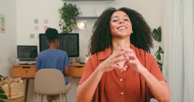 Mutlu, çeşitli bir kadın kameraya güvenle gülümserken, teknoloji ekibi modern bir ofiste dijital başlangıç projesi üzerinde çalışıyor, yenilik ve profesyonel çalışma sergiliyor..