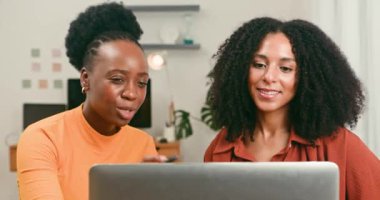 İki mutlu ve çeşitli kadın bir dizüstü bilgisayar üzerinde yakın bir işbirliği içinde, fikirleri paylaşıyor ve teknolojik girişimleri için yenilikçi stratejileri tartışıyorlar. Onların ortak görüşleri ve gülümsemeleri bir takım çalışması hissi verir..