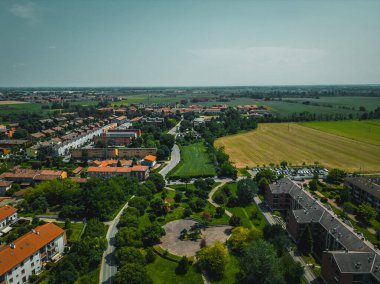 Panorama kırsal bölgesi İtalya Lombardiya bölgesi. Yabani laleli yeşil bir arazinin insansız hava aracı fotoğrafçılığı. Güneşli bir yaz gününde tepeden aşağı fotoğraf