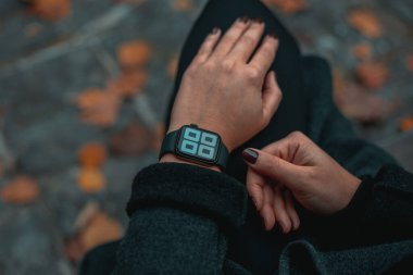 Elindeki akıllı bakışlara bakan bir kadın. Saat 12: 00 yönünde. Arka planı bulanık olan görüntüyü kapat. Tam çerçeve.