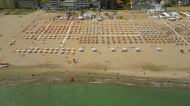 Renkli şemsiyeli Rimini plajı manzarası ve yaz günü dinlenen insanlar. Yüksek kalite 4k görüntü