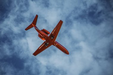 Kırmızı yolcu uçağı uçuyor. Bulutların üzerinde uçan kırmızı yolcu uçağının alt görüntüsü. Yüksek kalite fotoğraf