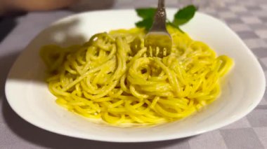 Enginar Pesto ve Ceviz Tarifi Yavaş çekim videolu spagetti. İtalyan kadın evde makarna yiyor, çatalla spagetti çeviriyor. Yüksek kalite 4k görüntü