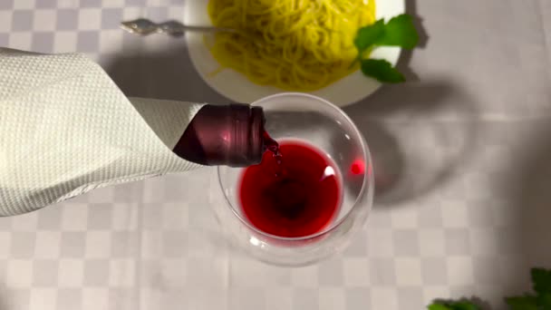 在餐桌和意大利面的背景下 加入红酒的杯子特写镜头 女人的手倒入美味的葡萄酒 准备喝酒和品酒的女人 高质量4K — 图库视频影像