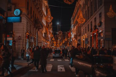 Akşamın Noel sokağı Milan. Montenapoleone Bölgesi. Milano, İtalya 'da Noel ve Yeni Yıl tatillerinde parıldayan çelenklerle süslenmiş sokak ve dükkanlar 4.12.2023. 