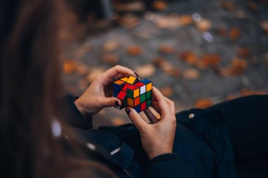 Elinde bir Rubik küp tutan bir kız. Rubik Küpü 90 'larda popülerdi. İnternetsiz bir çocukluk. Rebus, yap-boz. Yaratıcı fikirler kavramı. İtalya, Milano 6.11.2023. Yüksek kalite fotoğraf