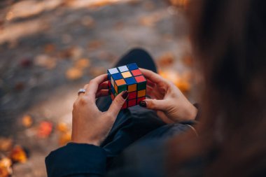 Elinde bir Rubik küp tutan bir kız. Rubik Küpü 90 'larda popülerdi. İnternetsiz bir çocukluk. Rebus, yap-boz. Yaratıcı fikirler kavramı. İtalya, Milano 6.11.2023. Yüksek kalite fotoğraf