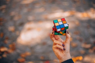 Elinde bir Rubik küp tutan bir kız. Rubik Küpü 90 'larda popülerdi. İnternetsiz bir çocukluk. Rebus, yap-boz. Yaratıcı fikirler kavramı. İtalya, Milano 6.11.2023. Yüksek kalite fotoğraf