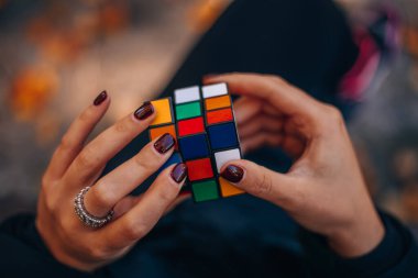 Elinde bir Rubik küp tutan bir kız. Rubik Küpü 90 'larda popülerdi. İnternetsiz bir çocukluk. Rebus, yap-boz. Yaratıcı fikirler kavramı. İtalya, Milano 6.11.2023. Yüksek kalite fotoğraf