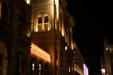 Noel boyunca Galleria Vittorio Emanuele II. Milano 'nun merkezinde akşam yürüyüşü ve alışveriş. Şehir Noel arifesinde. 