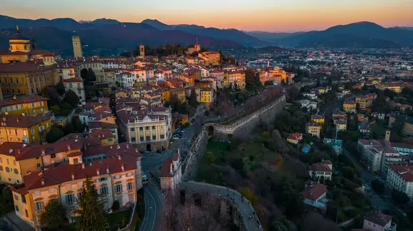 Bergamo, İtalya. Güneş doğarken eski kasabanın insansız hava görüntüsü. Şehir merkezindeki manzara, tarihi binalar. Citta Alta - Bergamo. 
