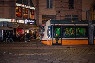 Milan, İtalya 18.12.2023. Milan sokaklarında modern tramvay. Milan 'ın tarihi merkezindeki akşam sokak şehri. Lombard 'ın başkenti Milan' da tipik İtalyan binaları ve sokak manzarası. 
