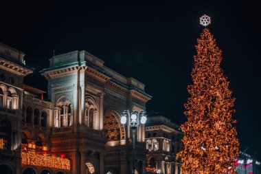 Milan, İtalya, 18.12.2023 Noel atmosferi. Piazza Duomo ve yılbaşı ağacı. Albero di Natale, renkli ışıklarla. Geceleri şehir. Duomo Meydanı 'ndaki aydınlık ağaç.. 