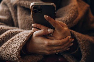 Akıllı telefonda sohbet eden, kısa mesaj yazan, dokunmatik ekran klavyesine dokunan, kurye uygulaması kullanan bir kadın. Milenyum kullanıcısı cep telefonu tutuyor, yakın çekim, kırpılmış çekim. Yüksek kalite fotoğraf