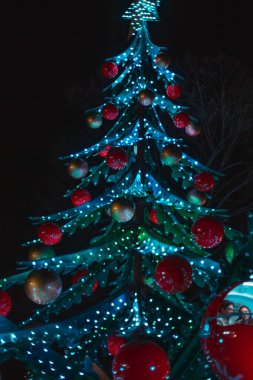Atlıkarınca cazibesi Noel ağacı şeklinde. Noel Köyü bir Milano. Villaggio delle Meraviglie. İtalya, Milan 03.01.2024. Yüksek kalite fotoğraf