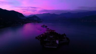 Maggiore Gölü 'nde güzel pembe gün batımı. Adanın havadan görünüşü, Isola Bella, Isola Superiore. İtalyan adasında yeni yıl tatili. Yüksek kalite 4k görüntü