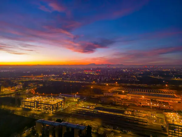 San Donato Milano şehrinin üzerinde bir İHA 'dan çekilmiş güzel pembe bir günbatımı. İnsansız hava aracından şehir manzarası. İtalya, Lombardiya, Milano, San Donato Milano. 