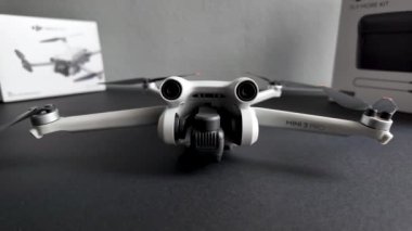 Drone kamera titreşimi yükselir ve dikey döner. Küçük ve hafif dron siyah bir masada 249 gram ağırlığında ve üç bataryalı modern insansız hava aracı..