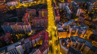 Milano şehrinin çatıları ve caddelerinin geceleri havadan görünüşü.