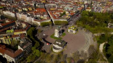 Zafer Kemeri ve gökdelenler dramatik gökyüzü ile şehrin ufuk çizgisi üzerinde. Sempione Porta Sempione kapısı sonbaharda Lombardy 'ye açılıyor. Barış Kemeri. Arco della tempo. Milano City Park 'ta güneşli bir akşam 