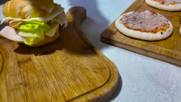 ハムと熟したレタスと溶けたチーズの大きな美味しいサンドイッチ イタリア人女性が台所の自宅でサンドイッチを作ります イタリアンサンドイッチ イタリア料理 ファストフードコンセプト — ストック動画