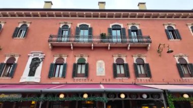 Verona, İtalya 03.2024. Verona İtalya 'nın tarihsel kısmını gezin. Bahar bulutlu bir günde Verona şehir merkezinde bir sürü insan dolaşıyor. İtalya seyahat konsepti. İtalyan mimarisi. 