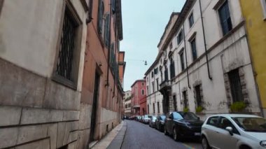 Verona, İtalya 03.2024. Verona 'nın tarihi bölgesinde bir sokak. Verona İtalya 'nın tarihsel kısmını gezin. Bahar bulutlu bir günde Verona şehir merkezinde bir sürü insan dolaşıyor. İtalya seyahat konsepti. İtalyan mimarisi. 
