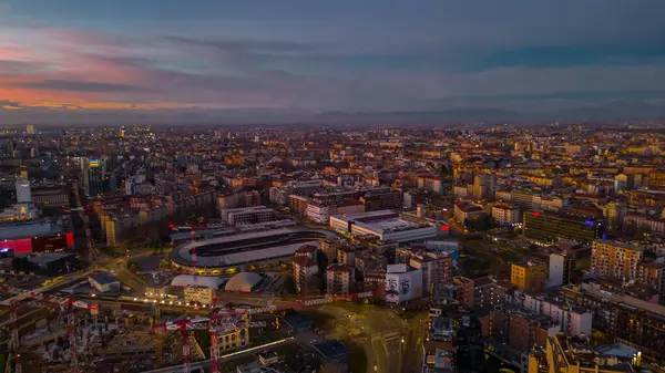 Gün batımında İtalyan metropolünün silueti. Panoramik ufuk çizgisi ve boş yolu olan modern ticari binalar. İtalya, Lombardiya, Milan. Yüksek kalite fotoğraf.
