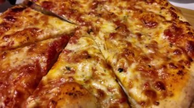 Mozzarella pizzasını dilimliyorum. Ağır çekimde yakın çekim. Fırından çıkan lezzetli İtalyan pizzası. Yemek ve 4k 'lık görüntüler. Yüksek kalite 4k görüntü