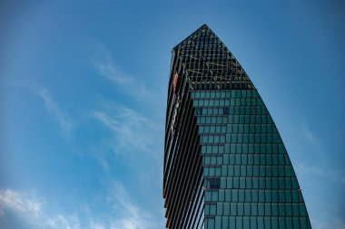 Mavi gökyüzünün arka planına karşı bir gökdelen cephesi. Milano Şehri Yaşam Bölgesi, Milan, Lombardy, İtalya 10.03. 2024. Yüksek kalite fotoğraf