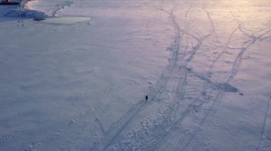 Donmuş Volga nehrindeki kız gün batımı videosunda İHA 'dan. Rusya, Togliatti, Samara bölgesi. Yüksek kaliteli FullHD görüntüler