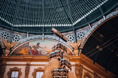 Milan, İtalya 03.01.2024 - Galleria Vittorio Emmanuel II in the evening during Christmas - Avrupa 'nın ilk atari salonlarından biri olan Milan' ın merkezinde kapalı bir alışveriş galerisi. Yüksek kalite fotoğraf